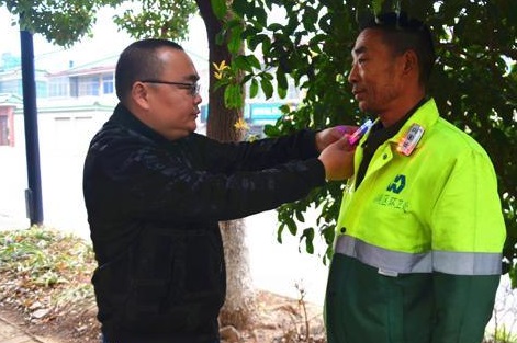 環(huán)衛(wèi)處工作人員為環(huán)衛(wèi)工人配發(fā)安全警示肩燈