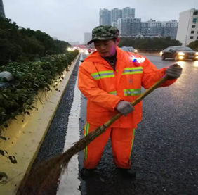 環(huán)衛(wèi)工人佩戴LED警示肩燈進(jìn)行路面清掃作業(yè)
